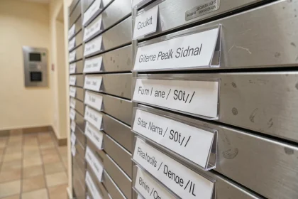 Boîte aux lettres d'immeuble avec étiquettes imprimées pour colocation affichant plusieurs noms par case